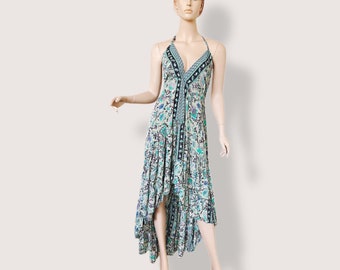 Könnte beinhalten: Ein Maxikleid im Halfter-Stil mit einem Blumendruck in Blautönen, Grün- und Weißtönen. Das Kleid hat einen hohen, niedrigen Saum, wobei der vordere Saum über dem Knie endet und der hintere Saum bis zu den Knöcheln reicht.