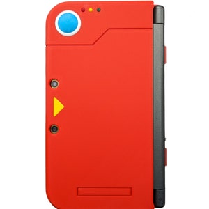 May include: A red handheld gaming console with a blue button and a yellow triangle on the front. The console has a black hinge on the right side.