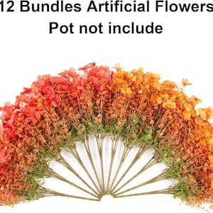 May include: Twelve bundles of artificial flowers arranged in a fan shape. The flowers feature a gradient of colours ranging from deep orange and red on the left to bright yellow and gold on the right. Text above reads: 12 Bundles Artificial Flowers, Pot not include.