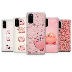 Può includere: Sei diverse custodie per telefono con il personaggio rosa del videogioco Kirby. Le custodie sono tutte rosa e bianche e presentano diversi design di Kirby. Una custodia ha una grande immagine di Kirby, un'altra ha un motivo del viso di Kirby e un'altra ha un motivo del corpo di Kirby.