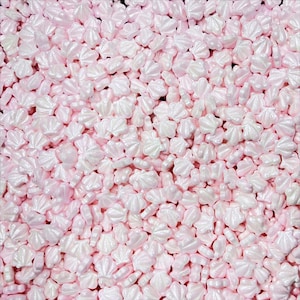 May include: Pink and white pearl-like sprinkles shaped like a flower. The sprinkles are perfect for decorating cakes, cupcakes, and other desserts.