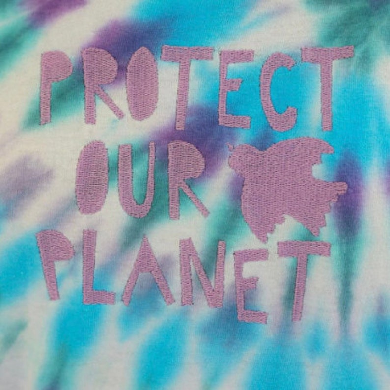 May include: A tie-dye t-shirt with the words "Protect Our Planet" embroidered in purple on the front.