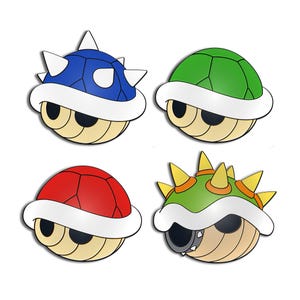 May include: Four cartoon turtle shells in blue, green, red, and green with yellow spikes. Each shell has a white rim and a tan body with black eyes. The shells are from a video game.