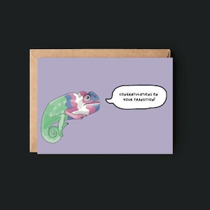 Puede incluir: Tarjeta de felicitación con un camaleón de dibujos animados en colores verde, azul, rosa y blanco. El camaleón está sobre un fondo lavanda y dice: "¡Felicitaciones por tu transición!" La tarjeta está dentro de un sobre marrón.