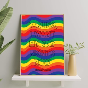 Puede incluir: Un póster de colores arcoíris con el texto "Darling, I want my gay rights now" en letras negras delineadas. La cita se atribuye a Marsha P. Johnson.