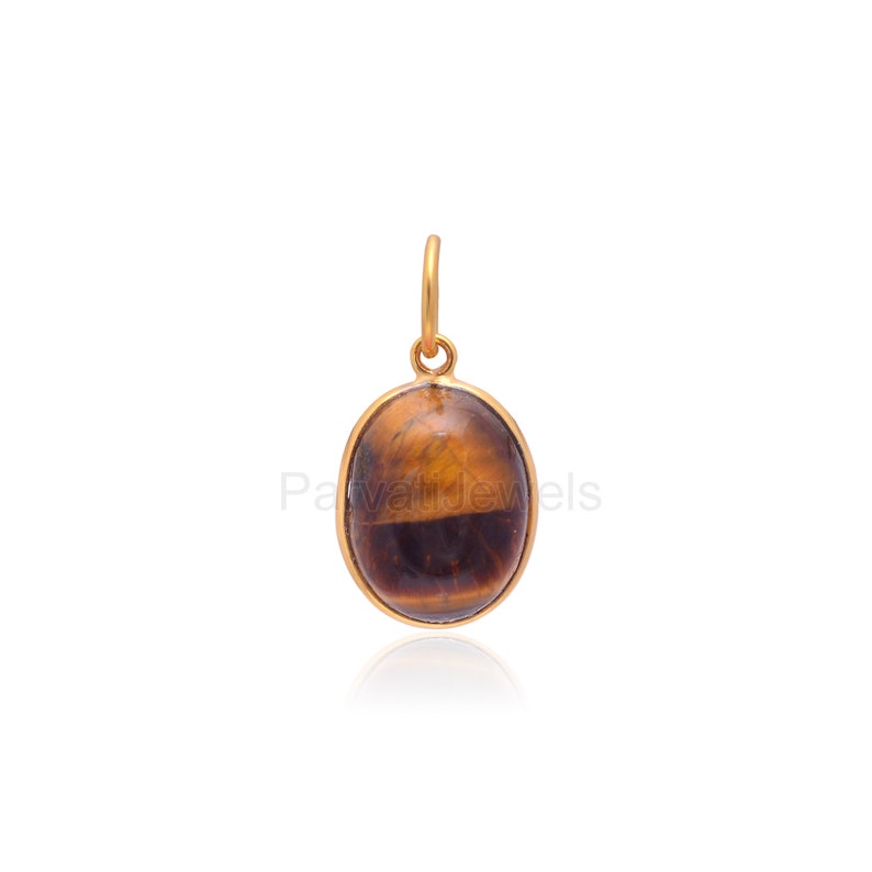 May include: Gold pendant featuring a brown and gold oval tiger's eye gemstone.