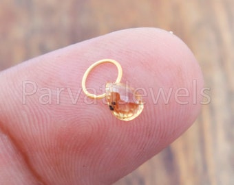 Puede incluir: Un aro de nariz de oro con una pequeña piedra preciosa facetada transparente.