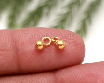 May include: Two gold-toned metal bead charms with a loop in the center. The charms are small and round, and they are perfect for adding a touch of elegance to jewelry projects.
