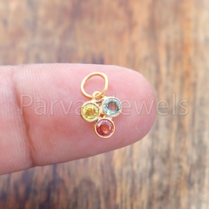Peut inclure: Un pendentif en or avec quatre petites pierres rondes de couleur jaune, verte, bleue et orange.