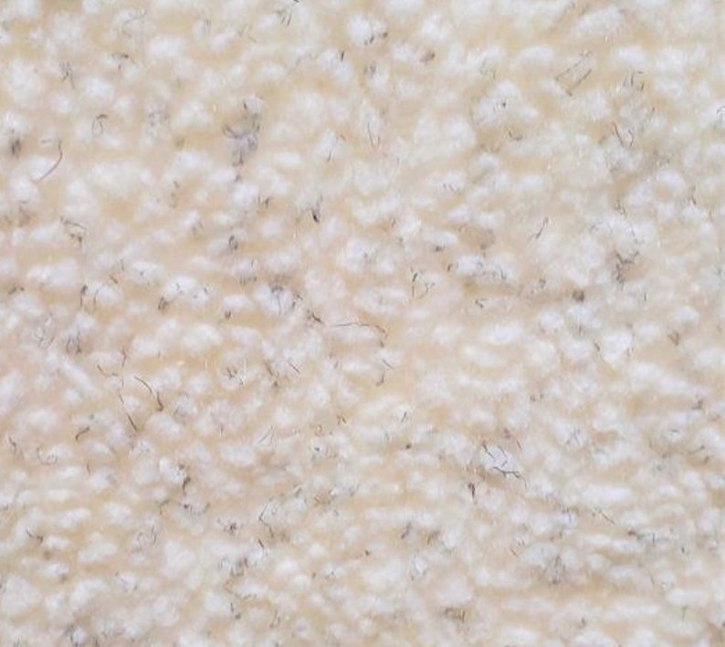 May include: Close-up of a white, fluffy, textured fabric. The fabric has a soft, fuzzy appearance.