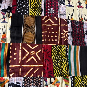 May include: A colorful patchwork fabric with various geometric patterns and stylized figures. The fabric features a mix of red, yellow, black, white, and brown colors.