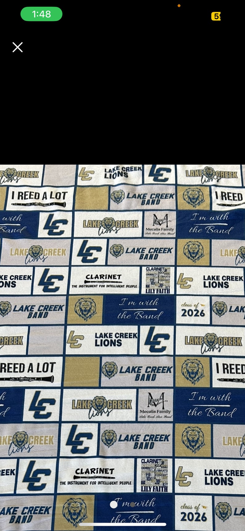 May include: Fabric with a repeating pattern of navy blue, gold, and white squares. Each square features text and graphics related to the Lake Creek Lions band, including the school logo, clarinets, and the phrase "I'm with the Band."