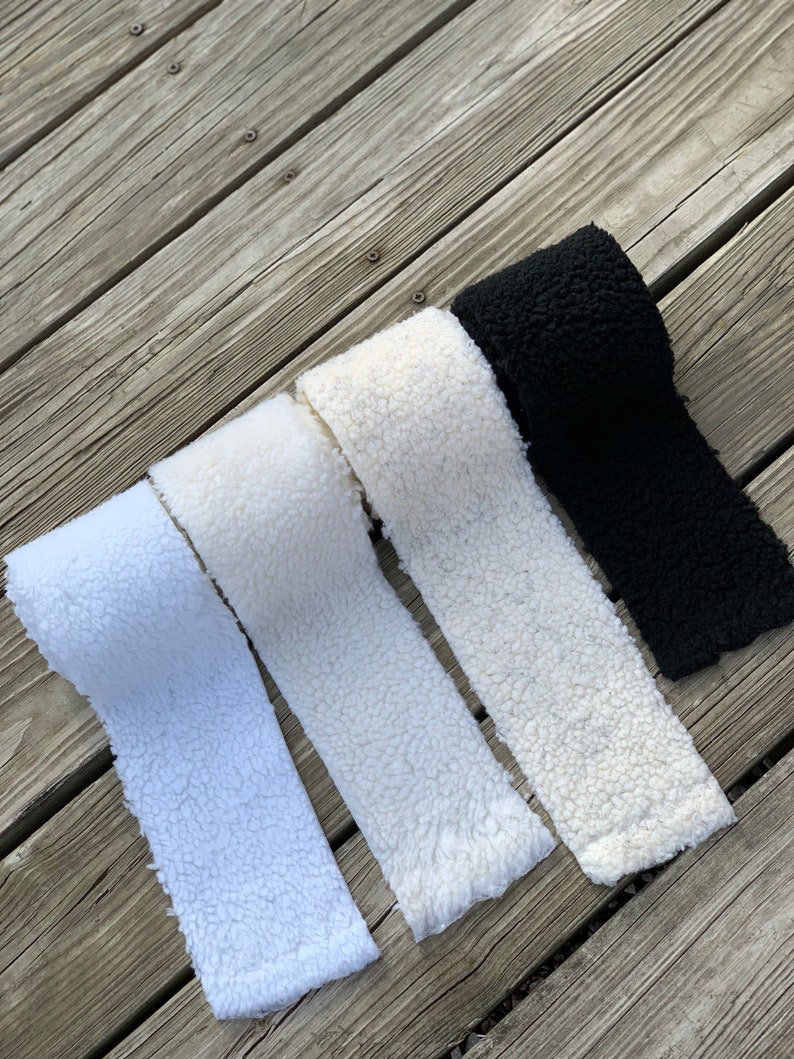 May include: Four rolls of white and black faux fur fabric. The fabric is soft and fluffy, and it would be perfect for making blankets, cushions, or other home decor items.