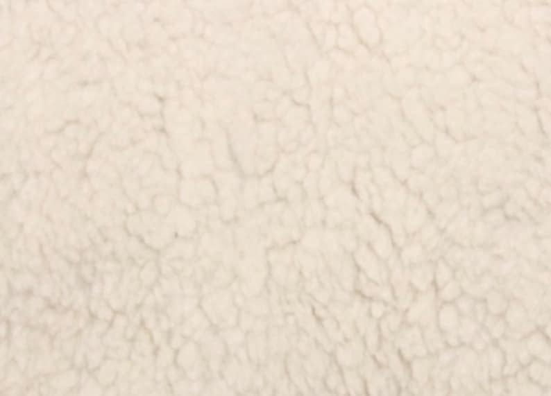 May include: Close-up of a soft, white, fluffy fabric with a textured surface.