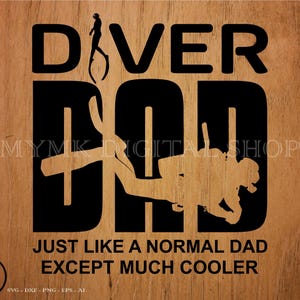 以下が含まれることがあります： 木目調の背景に黒いグラフィックデザイン。「DIVER DAD」の文字と、ダイバーのシルエットが「D」と「A」に組み込まれています。下には「JUST LIKE A NORMAL DAD EXCEPT MUCH COOLER」と書かれています。