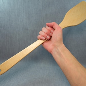 Puede incluir: Una tabla de cortar de madera hecha a mano con un acabado natural. La tabla presenta un borde vivo en un lado y mide aproximadamente 45 cm de largo, 30 cm de ancho y 2,5 cm de grosor.