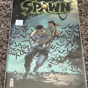 May include: Comic book cover for Spawn #94, featuring a distressed man carrying a child, with a background of bats. The title "SPAWN" is in green and gold. The cover includes the text "SPAWN.COM".