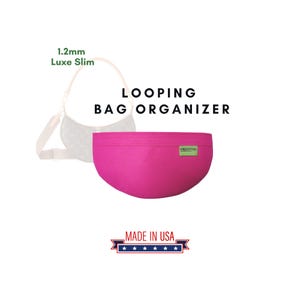Puede incluir: Un organizador de bolso de fieltro rosa con el texto "LOOPING BAG ORGANIZER" y "GREEN TAG" impreso en él. El organizador está hecho en los EE. UU. y es de 1,2 mm Luxe Slim.