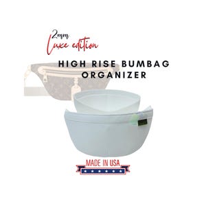 Op de afbeelding: Een lichtblauwe High Rise Bumbag Organizer, met de tekst "2mm Luxe edition". De organizer is gemaakt in de VS. De afbeelding toont de organizer met een omtrek van een heuptas op de achtergrond.