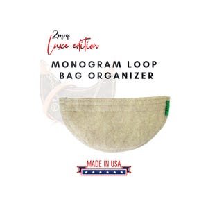 May include: Beige felt bag organizer with a green "Green Tas" label. The organizer is shaped like a half-circle and has a stitched edge. The text "2mm Luxe edition MONOGRAM LOOP BAG ORGANIZER" is above the organizer. The text "MADE IN USA" is below the organizer with five stars.