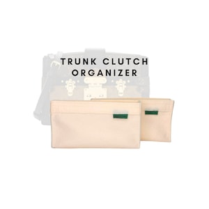 May include: Two beige felt trunk clutch organizers with green "Greentags" labels. The text "TRUNK CLUTCH ORGANIZER" is visible above the organizers.