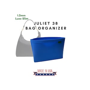 Peut inclure: Un organisateur de sac bleu vif avec le texte "JULIET 38 BAG ORGANIZER" et "MADE IN USA". Un sac à main gris clair est montré en arrière-plan. L'organisateur est de forme rectangulaire.