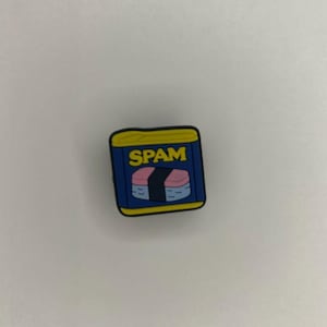 Pode incluir: Uma lata de Spam de desenho animado azul e amarela com a palavra "Spam" impressa na frente. A lata contém uma fatia de Spam rosa e branca.