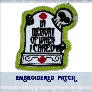 May include: Embroidered patch with a green tombstone, a skull, and the text "In memory of when I cared".