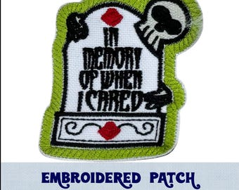 May include: Embroidered patch with a green tombstone, a skull, and the text "In memory of when I cared".