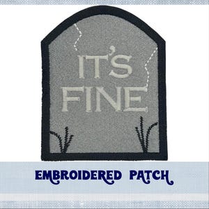 May include: Embroidered patch featuring a grey tombstone design. The tombstone has black stitching around the edges and the text "IT'S FINE" in white embroidery.
