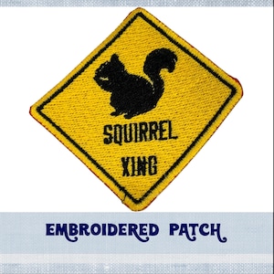 Peut inclure: Patch brodé jaune avec une silhouette noire d'un écureuil et le texte "Squirrel Xing".