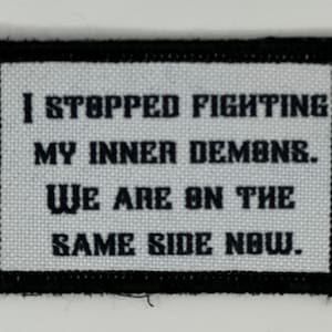 Peut inclure: Écusson rectangulaire avec une bordure noire et un fond blanc. Le texte se lit : "I STOPPED FIGHTING MY INNER DEMONS. WE ARE ON THE SAME SIDE NOW."