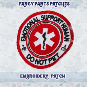 May include: White embroidered patch with a red circle and a white medical symbol. The circle has black text that reads "Emotional Support Human Do Not Pet" with a middle finger pointing up on each side.