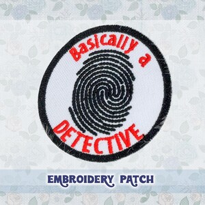May include: White embroidered patch with a black fingerprint and red text that reads "Basically a Detective".