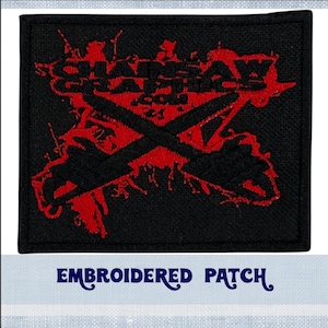 May include: Black embroidered patch with red splatter paint and the text "SHADOW GRAPHICS" in white. The patch features two crossed axes.