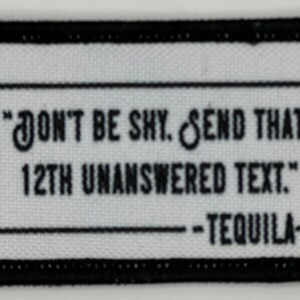 May include: Black and white embroidered patch with the text "Don't be shy. Send that 12th unanswered text." - Tequila.