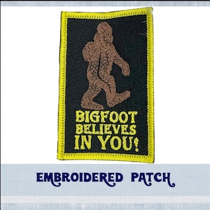 May include: Embroidered patch with a brown Bigfoot figure walking and the text "BIGFOOT BELIEVES IN YOU!" in yellow lettering on a black background with a yellow border.