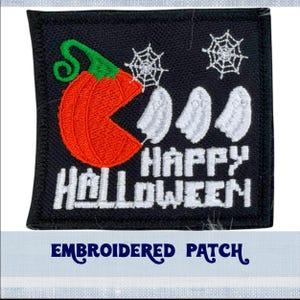 May include: Embroidered patch with a black background, a pumpkin with an open mouth eating three white ghosts, and the text "Happy Halloween" in white.