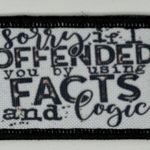 May include: White fabric patch with black text that reads "sorry if I OFFENDED you by using FACTS and logic". The patch has a black border.