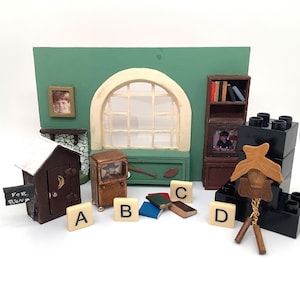May include: A miniature dollhouse scene with a green wall, a window, a bookshelf, a fireplace, a outhouse, a television, and a clock. The scene is decorated with wooden letters, books, and a sign that says "For Rent".