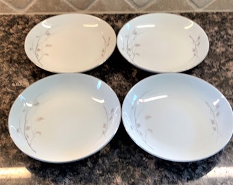 May include: Set of four white ceramic salad plates with a silver rim and a delicate gray floral design.