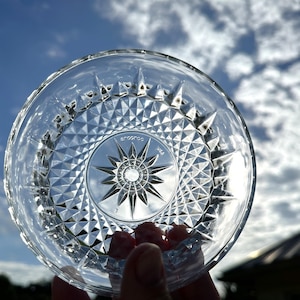 May include: A clear glass dish with a starburst pattern and a raised rim. The dish is marked "Aroostoc USA".