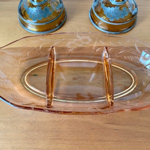 May include: A clear glass divided serving dish with a pink hue and etched floral designs.