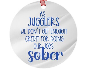 May include: White round ornament with blue text that reads "As Jugglers We Don't Get Enough Credit For Doing Our Jobs Sober".