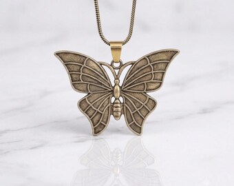 Collar con colgante de mariposa de latón, joyería bohemia inspirada en la naturaleza, pieza con mensaje espiritual.