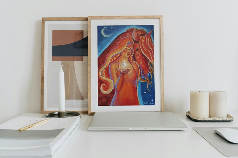 May include: Framed art print featuring a woman with long, flowing red hair holding a glowing star, with a horse. The artwork is set against a blue night sky with a crescent moon and stars. The color palette includes reds, oranges, and blues.