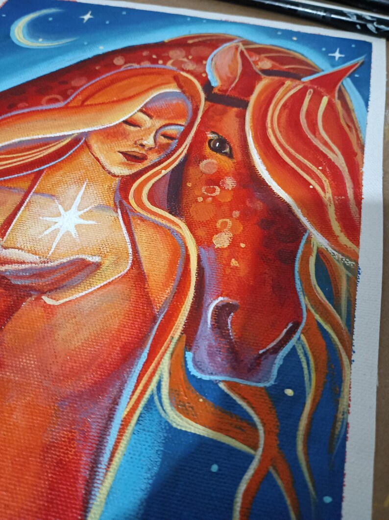 May include: An original painting depicts a woman with flowing red hair embracing a red horse. The woman holds a glowing star. The background is a deep blue with a crescent moon and stars. The artwork is on canvas.