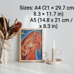 May include: A framed art print featuring a woman with long red hair holding a glowing orb, with a horse in the background. The print is in a wooden frame. Sizes: A4 (8.3 x 11.7 in) and A5 (5.8 x 8.3 in). A vase with dried flowers and a candle holder are also present.
