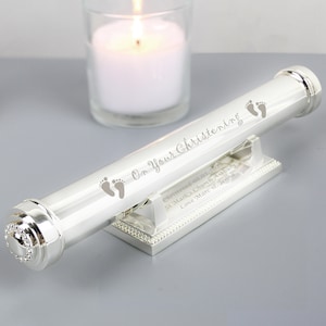 May include: Silver keepsake box with a scroll inside. The scroll is engraved with the text "On Your Christening" and a pair of baby footprints. The box is engraved with the text "Christened 08.01.2021 St. Mark's Church Ashbury Love Marc & Jenna".