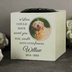 May include: A square, cream-coloured pet memorial box with a black top. A circular photo of a golden retriever is centered on the front, with the text "If Love Could Have Saved You, You Would Have Lived Forever Willow 2014-2024."